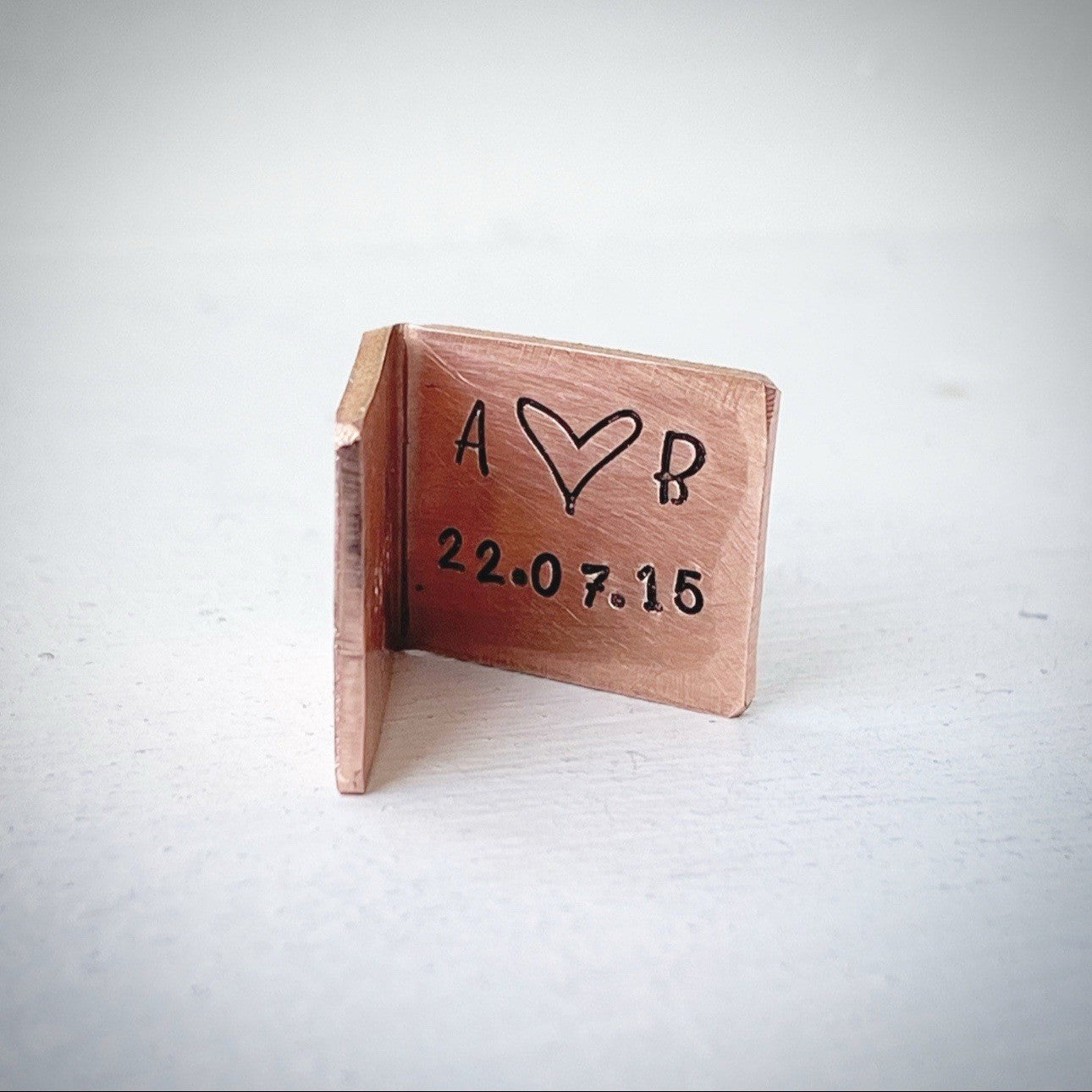 A bronze wedding anniversary card with custom initials and date engraved inside.