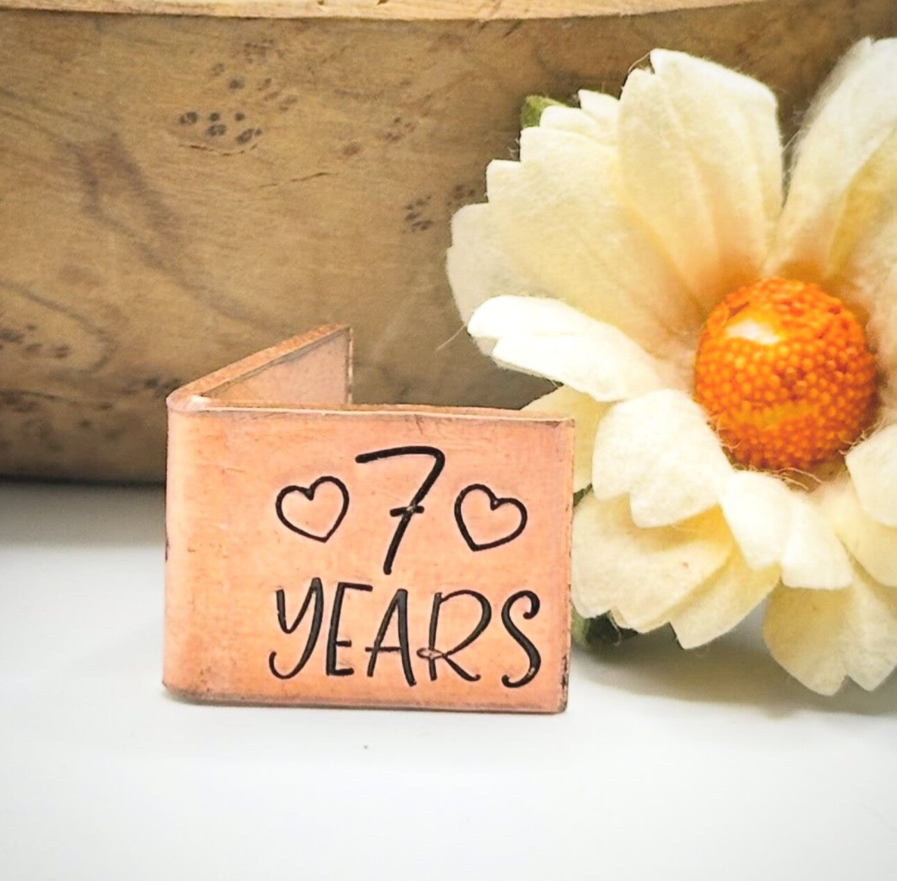 A personalized copper 7th wedding anniversary card with '7 YEARS' engraved.