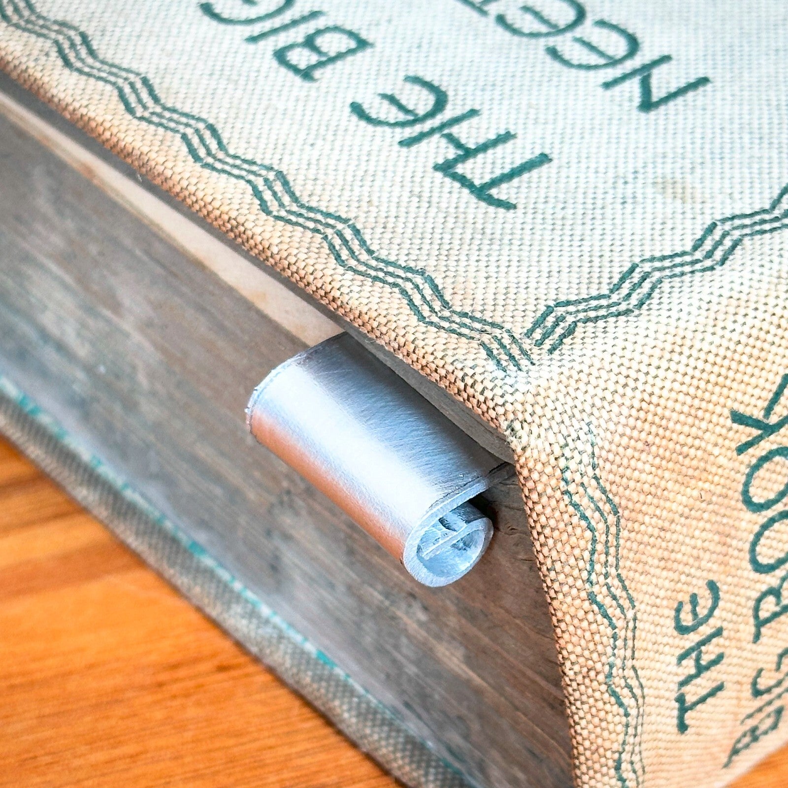 A silver aluminum bookmark with the inscription 'TO MANY MORE CHAPTERS TOGETHER' stamped on it.