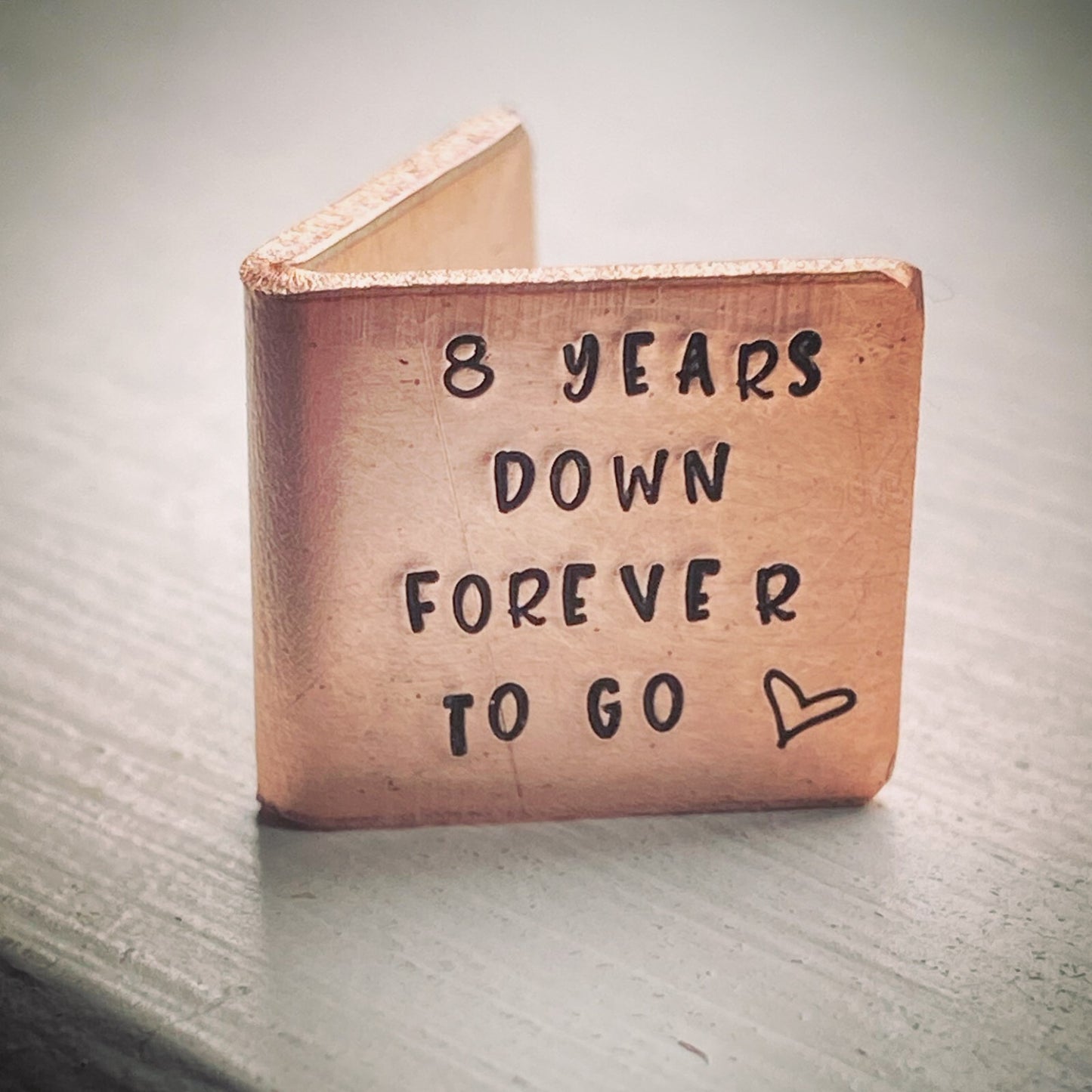 A personalized bronze wedding anniversary gift card with the inscription '8 YEARS DOWN FOREVER TO GO' .