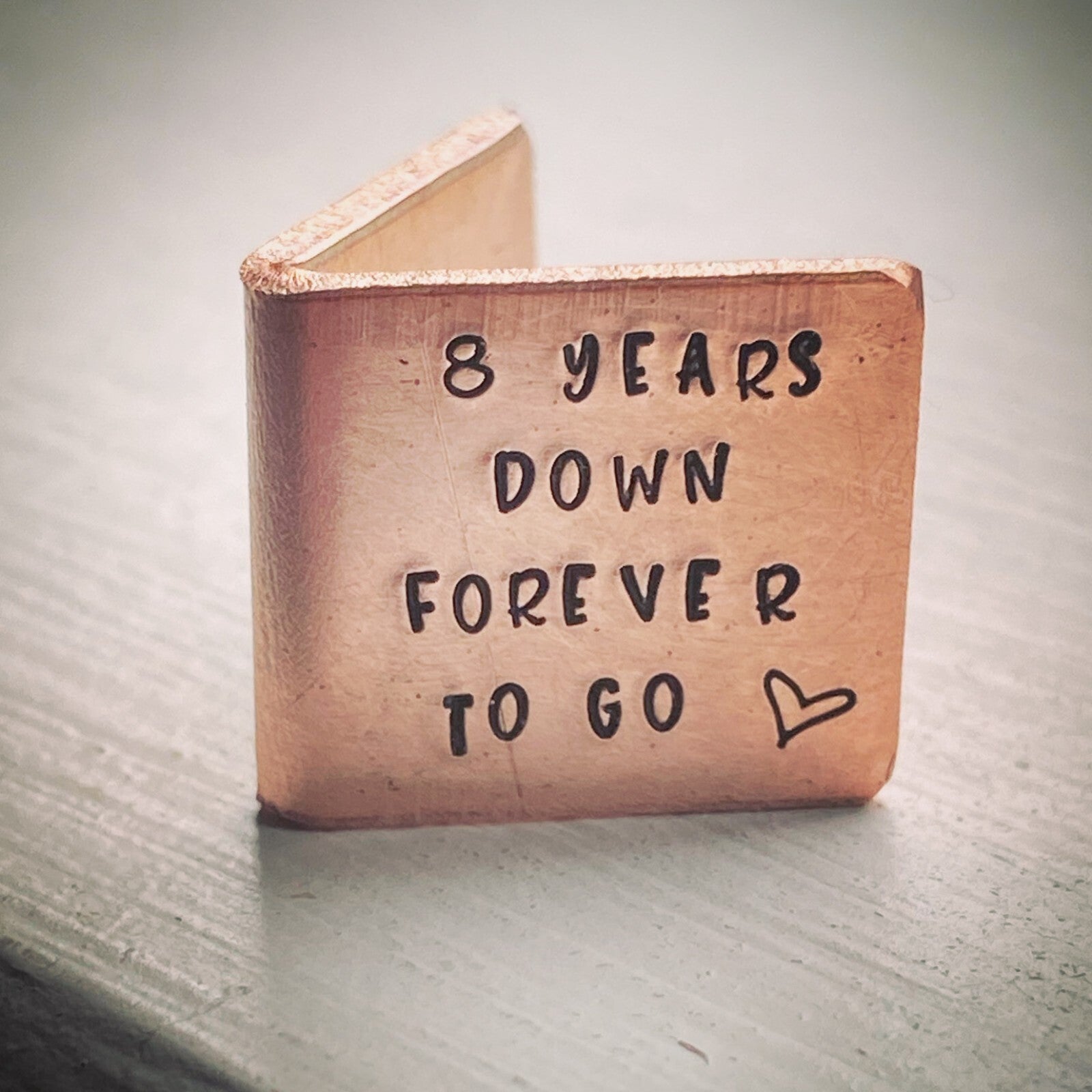 A personalized bronze wedding anniversary gift card with the inscription '8 YEARS DOWN FOREVER TO GO' .